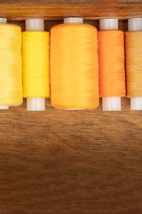 An overhead closeup photo of vibrant yellow and orange thread spools