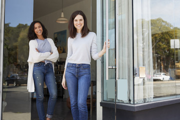 Female business owners in the doorway of their coffee shop