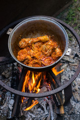 Cooking Harcho or Kharcho traditional Georgian soup food in Mingrelia with beef or chicken decorated with fresh chopped coriander leaves. Making kharcho in kettle on open fire. Georgia Samegrelo food