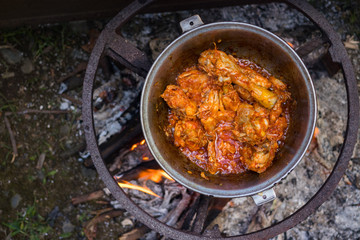Cooking Harcho or Kharcho traditional Georgian soup food in Mingrelia with beef or chicken decorated with fresh chopped coriander leaves. Making kharcho in kettle on open fire. Georgia Samegrelo food