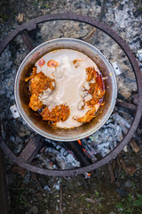Cooking Harcho or Kharcho traditional Georgian soup food in Mingrelia with beef or chicken decorated with fresh chopped coriander leaves. Making kharcho in kettle on open fire. Georgia Samegrelo food