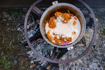 Cooking Harcho or Kharcho traditional Georgian soup food in Mingrelia with beef or chicken decorated with fresh chopped coriander leaves. Making kharcho in kettle on open fire. Georgia Samegrelo food