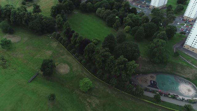 Aerial footage over high rise flats and Callendar Park in Falkirk, Scotland.