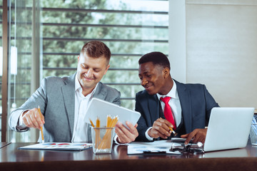 Portrait of two business partners sitting at a table together and working.