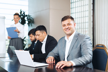Business people meeting around a boardroom table discussing strategy