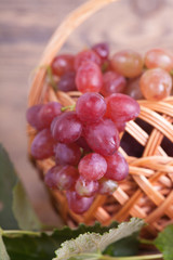 Basket with grapes against an old wooden wall