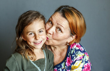 Grandma kisses her beloved granddaughter on the cheek