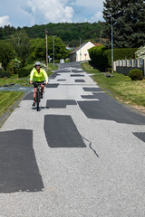 Vielfach ausgebesserte Straße in einer Gemeinde