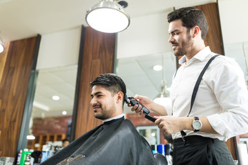 Professional Barber Trimming Client's Hair In Salon