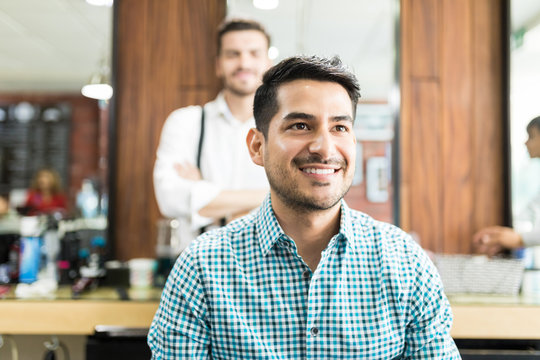 Smiling Young Man Looking Away After Haircut At Salon