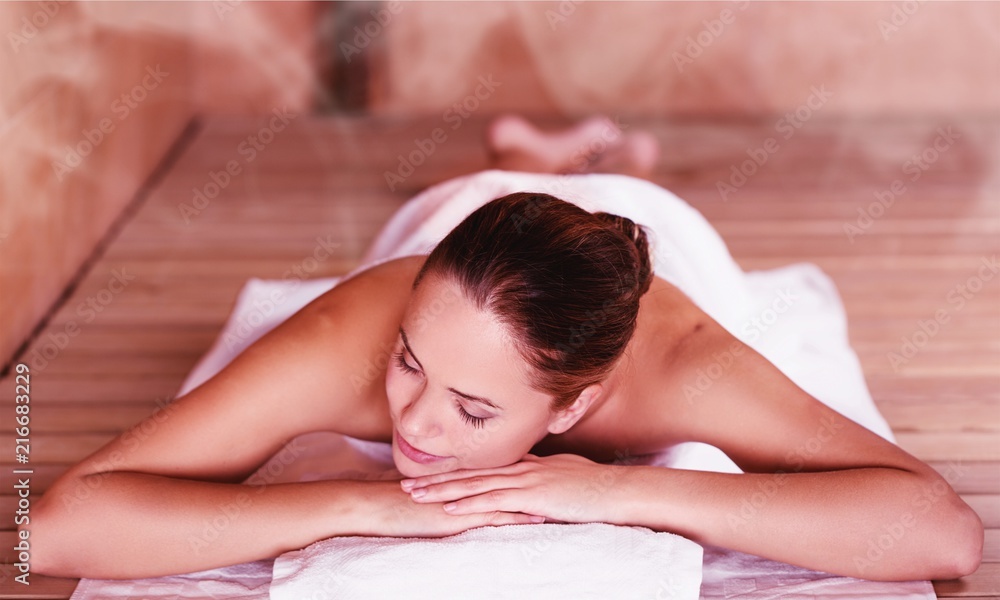 Wall mural young woman relaxing in spa