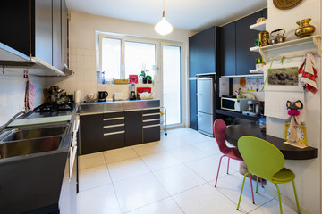 Kitchen with dark furniture and bright window