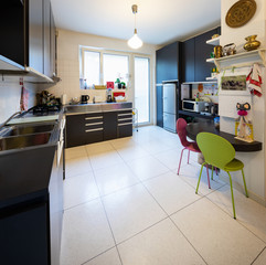 Kitchen with dark furniture and bright window