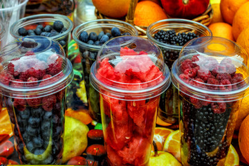 fresh organic berries: blackberries, raspberries, watermelon in transparent glasses on the table for sale.