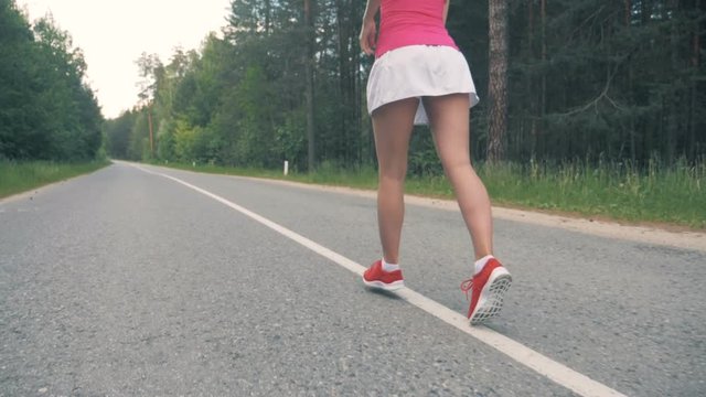 Young healthy woman running along the road. Healthy lifestyle concept.