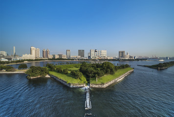 View of the bay of Odaiba with daiba park and the beach in the distance.