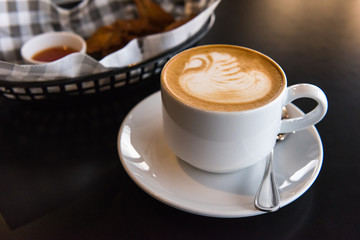 Flat white coffee cup  with snack on black table