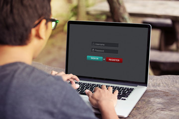 Man working and sign in membership username password on laptop / computer at the park / outdoor