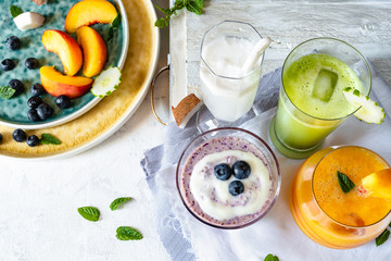 peach and melon smoothie, coconut smoothie, cucumber extract and blueberry milkshake, with dish full of fresh fruit
