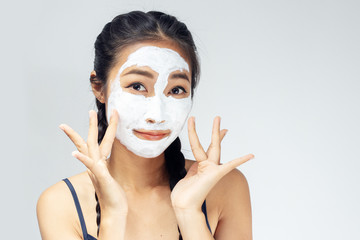 A woman is marking a face with mud.