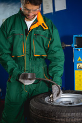 Worker inflate tire in workshop