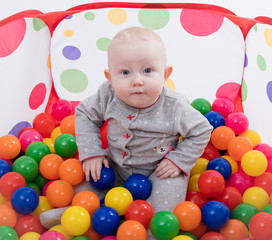 Fototapeta na wymiar Baby playing with balls in the playground 