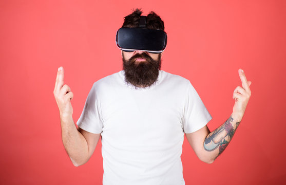 Shooting VR Game. Man Bearded Hipster With Virtual Reality Headset On Red Background. Man Hand Gesture As Gun Play Shooter Game In VR Glasses. First Person Shooter Shows How Addictive VR Could Be