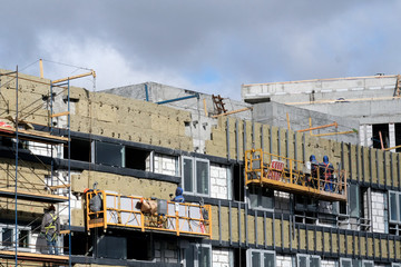 New building construction site with scaffolding and workers
