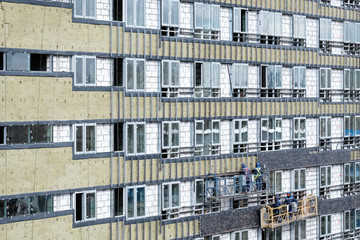Obraz premium New building construction site with scaffolding and workers