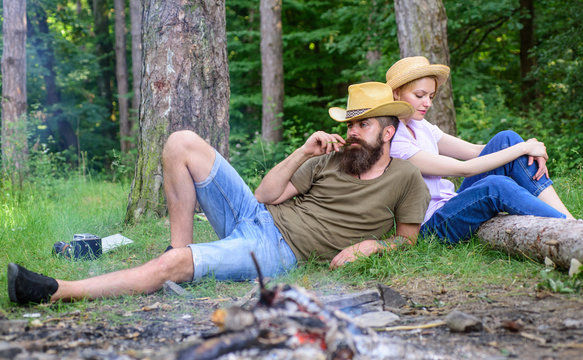 Family traditions. Family activity for summer vacation in forest and nature. Couple relaxing after gathering mushrooms in wild for food. Family relaxing near bonfire after day of mushroom hunting