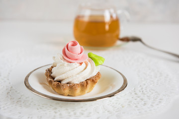 Tasty mini cake with tea on a white background