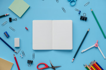 notebook open with school supplies stationery equipment on blue backboard Flat lay with copy space. back to school concept