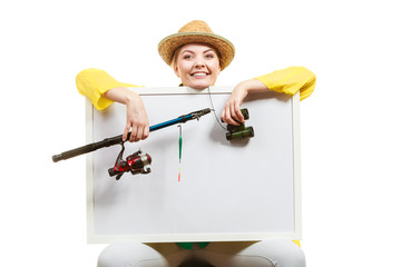 Happy woman with fishing rod holding board