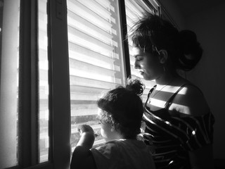 mom and baby look from the window film noir style black and white