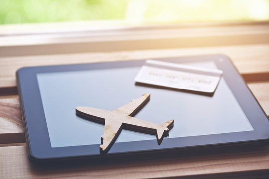 Airplane symbol with credit card and tablet computer. Online ticket booking concept