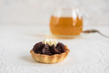 Tasty mini cake with tea on a white background