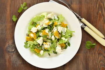 Salad with corn, greens, feta with mayonnaise sauce, top view