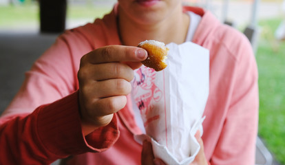 Young woman with doughnut hole and powdered sugar for breakfast food.