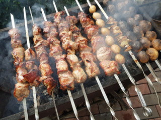 pork, onions and potatoes skewers on barbecue