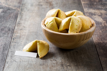 Fortune cookies in wooden bowl on wooden table