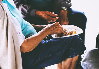 Elderly couple sharing funnel cake food during summer fair.