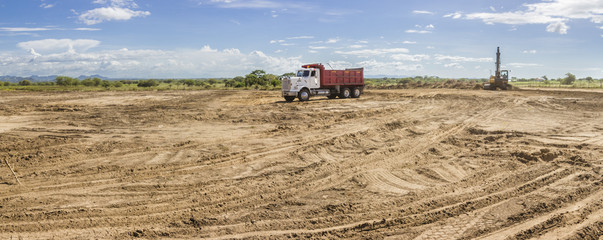 Trucks and heavy machinery clearing the land for the construction of a Solar Energy PV Plant at...