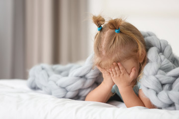 Cute little girl lying on bed at home