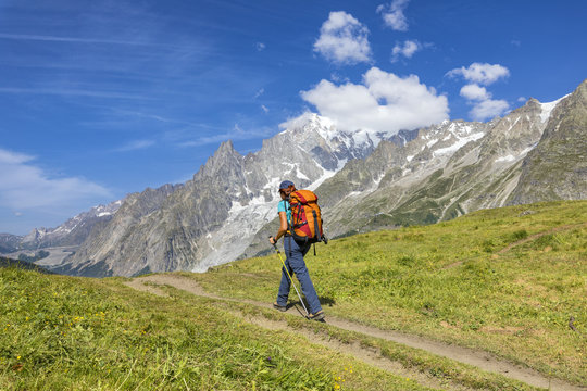 A trekker is walking in front of the Mont Blanc during the Mont Blanc hiking tours (Ferret Valley, Courmayeur, Aosta province, Aosta Valley, Italy, Europe).