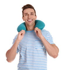 Happy young man with neck pillow on white background