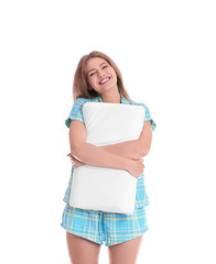 Young woman in pajamas embracing pillow on white background
