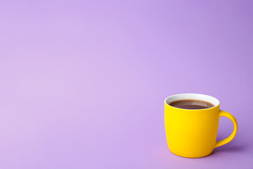 Yellow ceramic cup with hot aromatic coffee on color background