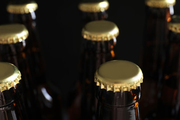 Many bottles of beer on dark background, closeup view