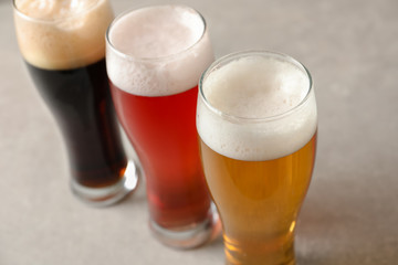 Glasses with different types of cold tasty beer on table, closeup