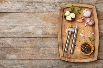 Flat lay composition with garlic press on wooden table